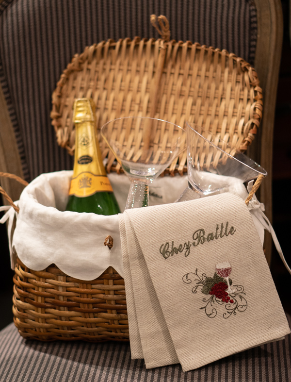 picnic basket with dish towel and champagne